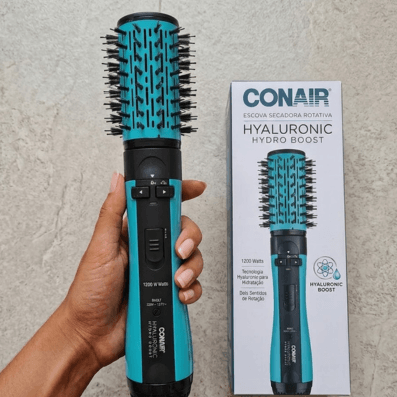 Mulher segurando escova secadora rotativa rotating hyaluronic conair